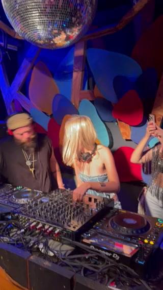 People gathered around a DJ booth at a vibrant indoor party
